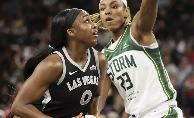 Las Vegas Aces guard Jackie Young (0) looks to the basket near Seattle Storm guard Jordan Horston (23) during a first-round WNBA basketball playoff game Sunday, Sept. 22, 2024, in Las Vegas. (AP Photo/Ronda Churchill)