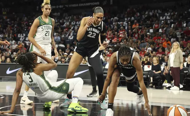 Las Vegas Aces guard Tiffany Hayes (15) from right, Las Vegas center A'ja Wilson (22) and Seattle Storm center Mercedes Russell (21) react to a loose ball under the net during a first-round WNBA basketball playoff game, Sunday, Sept. 22, 2024, in Las Vegas. (AP Photo/Ronda Churchill)