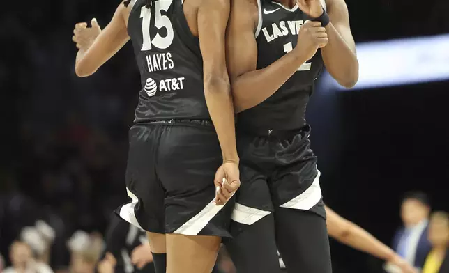 Las Vegas Aces guard Chelsea Gray (12), right, and Las Vegas Aces guard Tiffany Hayes (15) celebrate a shot during a first-round WNBA basketball playoff game against the Seattle Storm, Sunday, Sept. 22, 2024, in Las Vegas. (AP Photo/Ronda Churchill)