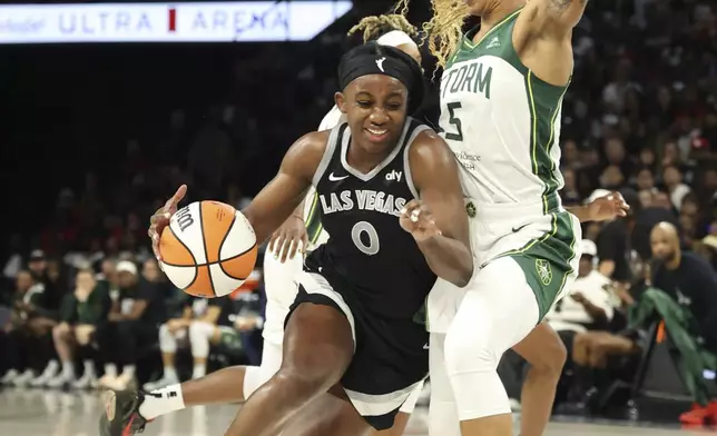 Las Vegas Aces guard Jackie Young (0) drives the ball around Seattle Storm forward Gabby Williams (5) during a first-round WNBA basketball playoff game Sunday, Sept. 22, 2024, in Las Vegas. (AP Photo/Ronda Churchill)