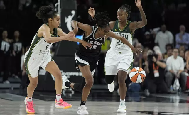 Las Vegas Aces guard Tiffany Hayes (15) drives against Seattle Storm guard Skylar Diggins-Smith (4) and guard Jewell Loyd (24) during the second half in Game 2 of a WNBA basketball first-round playoff game Tuesday, Sept. 24, 2024, in Las Vegas. (AP Photo/John Locher)