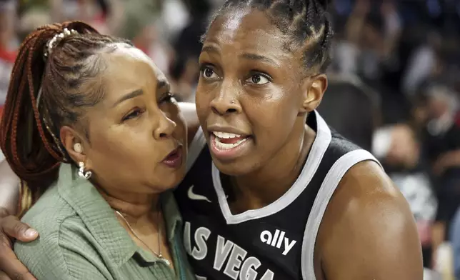 Las Vegas Aces guard Chelsea Gray (12) embraces mother Vickey Gray after winning a first-round WNBA basketball playoff game against the Seattle Storm, Sunday, Sept. 22, 2024, in Las Vegas. (AP Photo/Ronda Churchill)