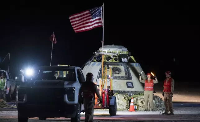 In this photo provided by NASA, Boeing and NASA teams work around NASA's Boeing Crew Flight Test Starliner spacecraft after it landed uncrewed, Friday, Sept. 6, 2024, at White Sands, New Mexico, after undocking from the International Space Station. (Aubrey Gemignani/NASA via AP)