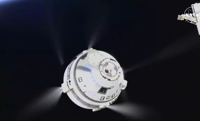 In this image from video provided by NASA, the unmanned Boeing Starliner capsule fires its thrusters as it pulls away from the International Space Station on Friday, Sept. 6, 2024. (NASA via AP)