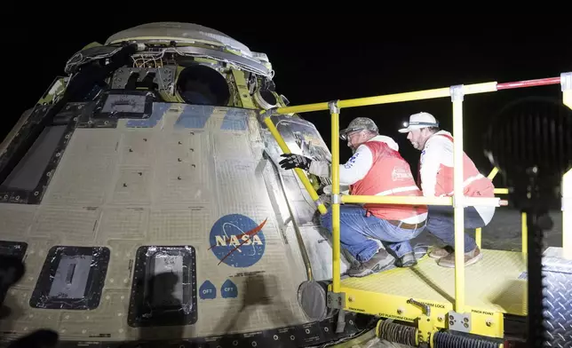 In this photo provided by NASA, Boeing and NASA teams work around NASA's Boeing Crew Flight Test Starliner spacecraft after it landed uncrewed, Friday, Sept. 6, 2024, at White Sands, New Mexico, after undocking from the International Space Station. (Aubrey Gemignani/NASA via AP)