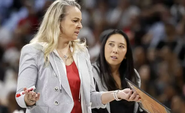 Las Vegas Aces head coach Becky Hammon, left, talks with assistant coach Natalie Nakase during the first half of a WNBA basketball game against the Connecticut Sun, Sunday, Sept. 15, 2024, in Las Vegas. (Steve Marcus/Las Vegas Sun via AP)