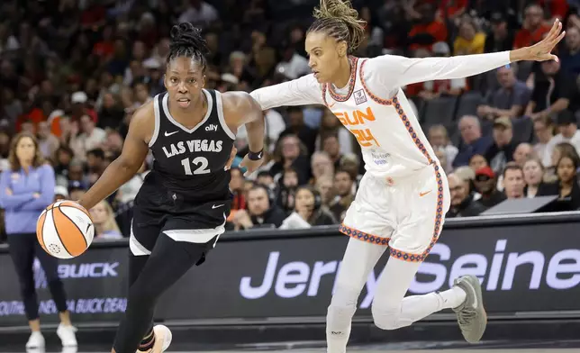 Las Vegas Aces guard Chelsea Gray (12) drives around Connecticut Sun forward DeWanna Bonner (24) during the first half of a WNBA basketball game Sunday, Sept. 15, 2024, in Las Vegas. (Steve Marcus/Las Vegas Sun via AP)