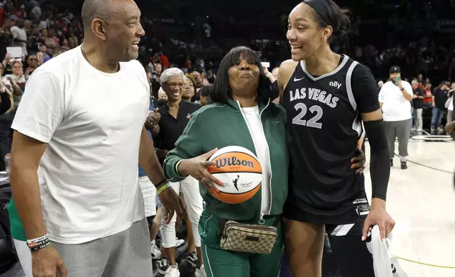 Las Vegas Aces center A'ja Wilson (22) celebrates with her parents Roscoe and Eva Wilson after an WNBA basketball game against the Connecticut Sun, Sunday, Sept. 15, 2024, in Las Vegas. (Steve Marcus/Las Vegas Sun via AP)