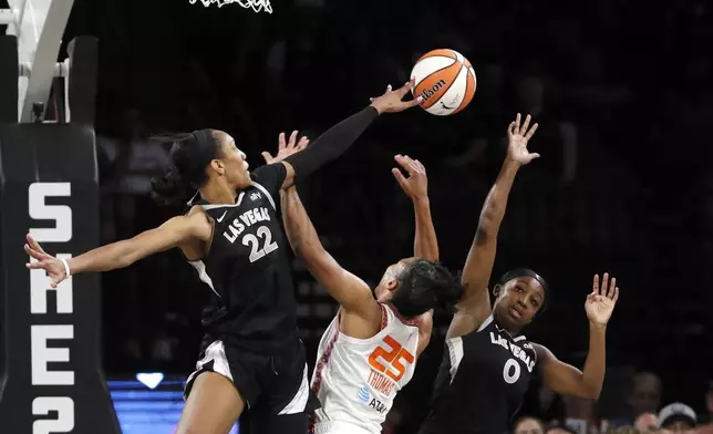 Connecticut Sun forward Alyssa Thomas (25) is fouled as she tries to shoot between Las Vegas Aces center A'ja Wilson (22) and guard Jackie Young (0) during the first half of a WNBA basketball game Sunday, Sept. 15, 2024, in Las Vegas. (Steve Marcus/Las Vegas Sun via AP)