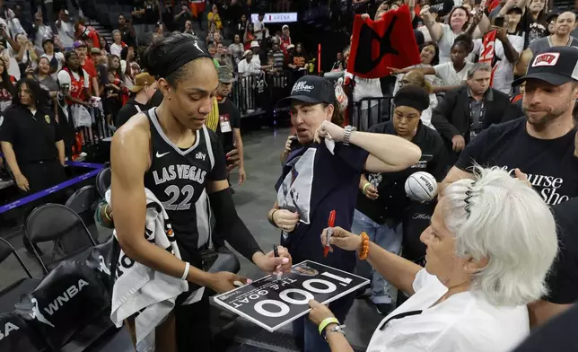 Las Vegas Aces center A'ja Wilson (22) signs autographs for fans after an WNBA basketball game against the Connecticut Sun Sunday, Sept. 15, 2024, in Las Vegas (Steve Marcus/Las Vegas Sun via AP)