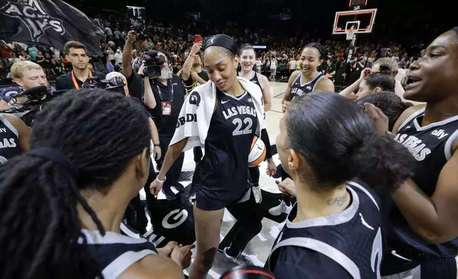 Las Vegas Aces center A'ja Wilson, center, celebrates with teammates after an WNBA basketball game against the Connecticut Sun, Sunday, Sept. 15, 2024, in Las Vegas. Wilson scored 29 points in the game to become the first WNBA player in WNBA history to reach 1,000 points in a regular season. (Steve Marcus/Las Vegas Sun via AP)