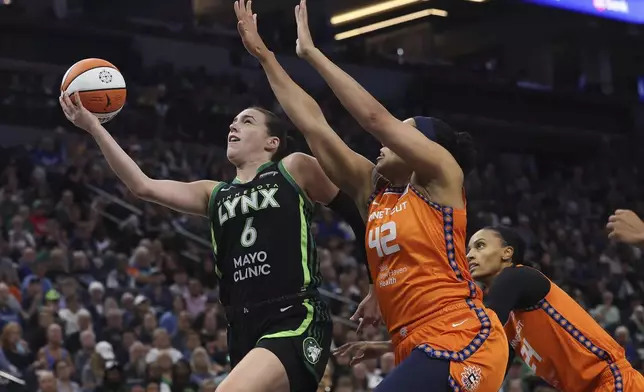 Minnesota Lynx forward Bridget Carleton (6) jumps up to the basket against Connecticut Sun forward Brionna Jones (42) during the first half of Game 1 of a WNBA basketball semifinals series Sunday, Sept. 29, 2024, in Minneapolis. (AP Photo/Stacy Bengs)