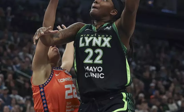 Minnesota Lynx forward Myisha Hines-Allen, right, goes up to the basket against Connecticut Sun guard Veronica Burton, left, during the first half of Game 1 of a WNBA basketball semifinals series Sunday, Sept. 29, 2024, in Minneapolis. (AP Photo/Stacy Bengs)