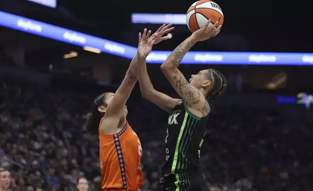 Minnesota Lynx guard Natisha Hiedeman, right, tries to make a basket against Connecticut Sun guard Veronica Burton, left, during the first half of Game 1 of a WNBA basketball semifinals series Sunday, Sept. 29, 2024, in Minneapolis. (AP Photo/Stacy Bengs)