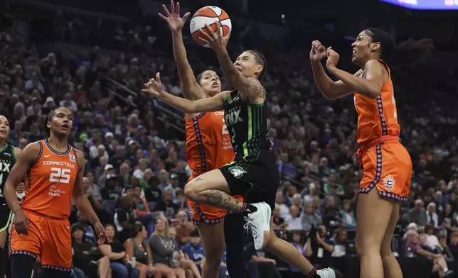 Minnesota Lynx guard Natisha Hiedeman (2) tries to make a basket against Connecticut Sun guard Veronica Burton, center left, during the first half of Game 1 of a WNBA basketball semifinals series Sunday, Sept. 29, 2024, in Minneapolis. (AP Photo/Stacy Bengs)