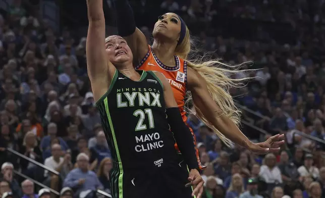 Minnesota Lynx guard Kayla McBride, left, goes up to the basket against Connecticut Sun guard DiJonai Carrington, right, during the first half of Game 1 of a WNBA basketball semifinals series Sunday, Sept. 29, 2024, in Minneapolis. (AP Photo/Stacy Bengs)