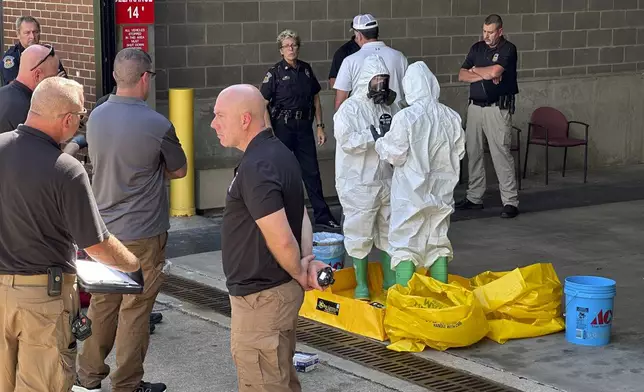 A hazmat crew from the National Guard's Civilian Support Team investigates after a suspicious package was delivered to election officials at the Missouri Secretary of State's Jefferson City, Mo., office on Tuesday Sept. 17, 2024. (AP Photo/Summer Ballentine)