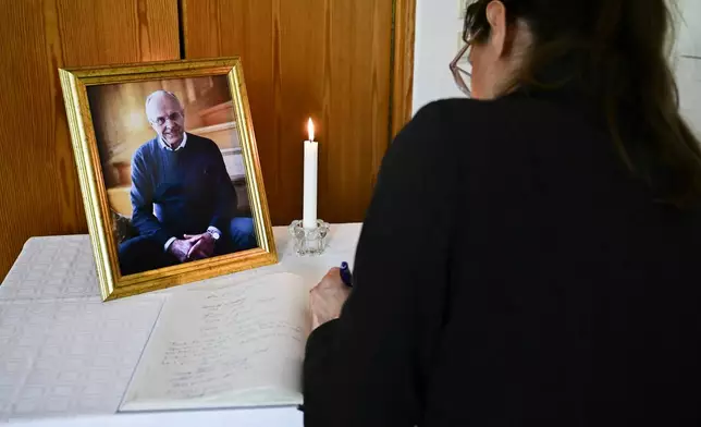 A woman signs a condolence book for the late Swedish soccer coach Sven-Goran Eriksson at the pastor's office in Torsby, Sweden, Thursday, Sept. 12, 2024. (Jonas Ekströmer/TT News Agency via AP)