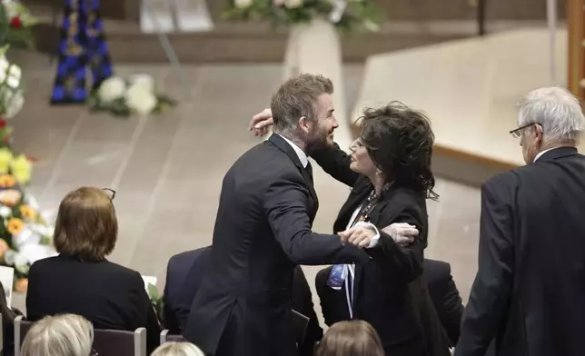 David Beckham and Nancy Dell'Olio hug as they arrive to attend the funeral service of Swedish soccer manager Sven-Goran Eriksson at Fryksände church in Torsby, Sweden, Friday Sept. 13, 2024. (Adam Ihse/TT News Agency via AP)