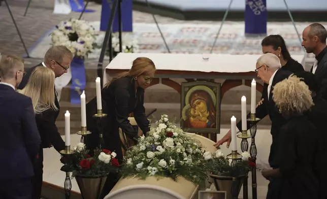 Sven-Goran Eriksson's partner Yaniseth Alcides, left, and his father Sven Eriksson, right, touch his coffin during the funeral service at Fryksände church in Torsby, Sweden, Friday Sept. 13, 2024. (Adam Ihse/TT News Agency via AP)