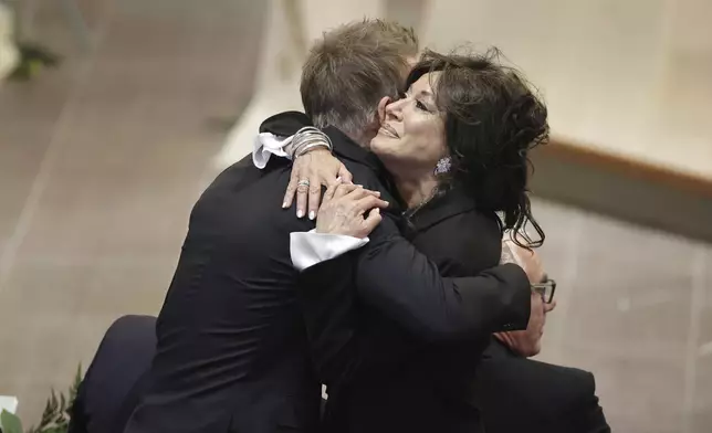 David Beckham and Nancy Dell'Olio hug as they arrive to attend the funeral service of Swedish soccer manager Sven-Goran Eriksson at Fryksände church in Torsby, Sweden, Friday Sept. 13, 2024. (Adam Ihse/TT News Agency via AP)