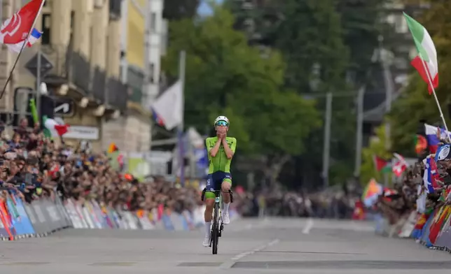 Slovenia's Tadej Pogacar reacts before crossing the finish line to win the Men Elite road race of the Cycling and Para-cycling Road World Championships in Zurich, Switzerland, Sunday, Sept. 29, 2024. (AP Photo/Peter Dejong)