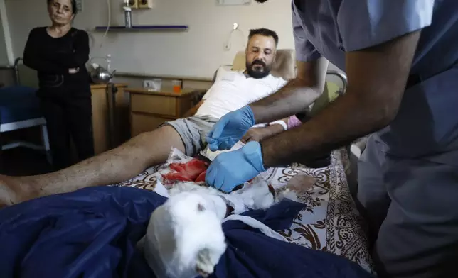 A Syrian nurse treats an man, who was injured, in the town of Masyaf, Syria, Monday, Sept. 9, 2024. Syrian state news agency SANA says that Israeli strikes hit several areas in central Syria Sunday night, damaging a highway in Hama province and sparking fires. (AP Photo/Omar Sanadiki)