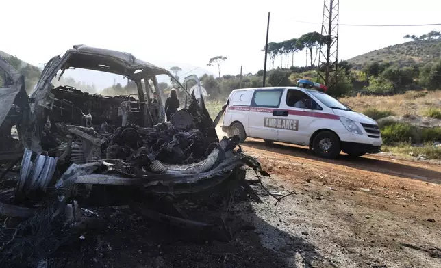 An ambulance drives past a vehicle that burned in the town of Masyaf, Syria, Monday, Sept. 9, 2024. Syrian state news agency SANA says that Israeli strikes hit several areas in central Syria Sunday night, damaging a highway in Hama province and sparking fires. (AP Photo/Omar Sanadiki)