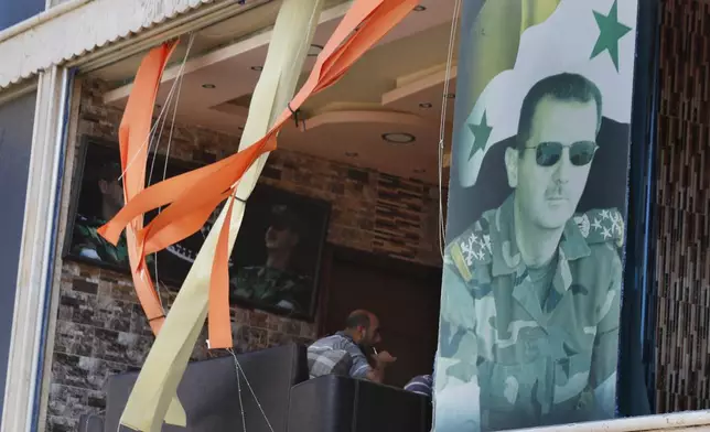 A poster shows Syrian President Bashar Assad installed at a broken window in the town of Masyaf, Syria, Monday, Sept. 9, 2024. Syrian state news agency SANA says that Israeli strikes hit several areas in central Syria Sunday night, damaging a highway in Hama province and sparking fires. (AP Photo/Omar Sanadiki)