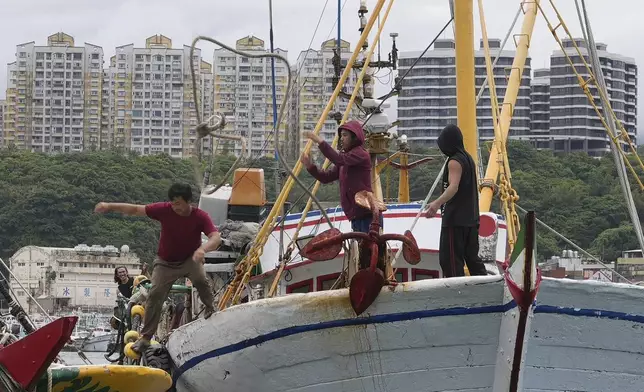 Workers tighten boats with ropes before Typhoon Krathon arrives, at a harbor in Keelung, Taiwan, Monday, Sept. 30, 2024. (AP Photo/Johnson Lai)