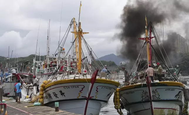 Workers tighten boats with ropes before Typhoon Krathon arrives, at a harbor in Keelung, Taiwan, Monday, Sept. 30, 2024. (AP Photo/Johnson Lai)