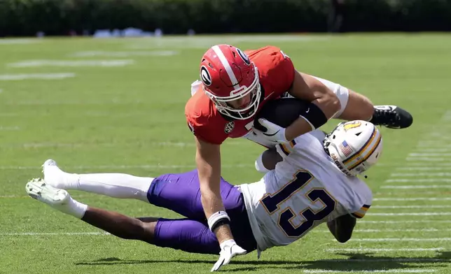 Georgia tight end Lawson Luckie (7) is brought down by Tennessee Tech defensive back Caldra Williford (13) after a catch during the first half of an NCAA college football game Saturday, Sept. 7, 2024, in Athens, Ga. (AP Photo/John Bazemore)