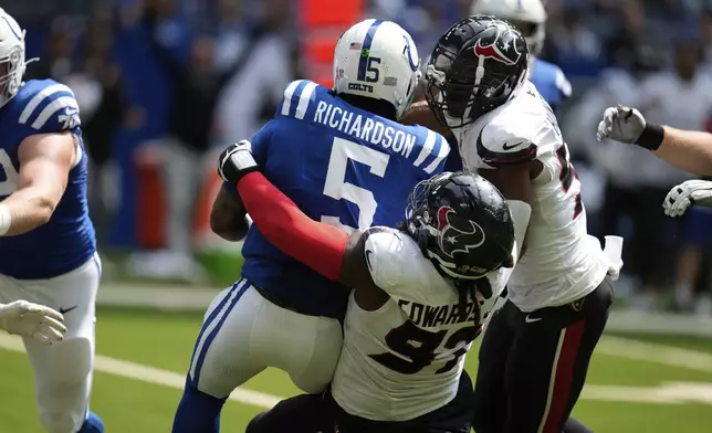 Indianapolis Colts quarterback Anthony Richardson (5) is sacked by Houston Texans defensive end Mario Edwards Jr. (97) during the first half of an NFL football game, Sunday, Sept. 8, 2024, in Indianapolis. (AP Photo/Darron Cummings)