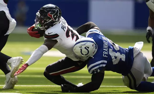 Houston Texans running back Dameon Pierce (31) is tackled by Indianapolis Colts linebacker Zaire Franklin (44) during the second half of an NFL football game, Sunday, Sept. 8, 2024, in Indianapolis. (AP Photo/Michael Conroy)