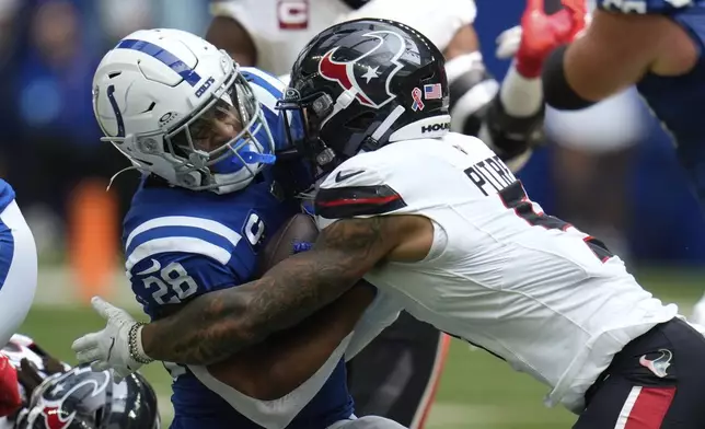 Indianapolis Colts running back Jonathan Taylor (28) is tackled by Houston Texans safety Jalen Pitre (5) during the first half of an NFL football game, Sunday, Sept. 8, 2024, in Indianapolis. (AP Photo/Darron Cummings)