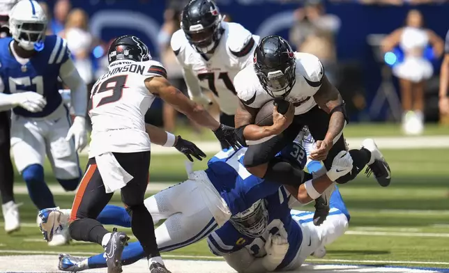 Indianapolis Colts safety Julian Blackmon (32) tackles Houston Texans running back Joe Mixon (28) during the second half of an NFL football game, Sunday, Sept. 8, 2024, in Indianapolis. (AP Photo/Michael Conroy)