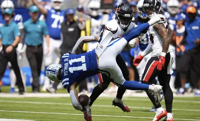 Indianapolis Colts wide receiver Michael Pittman Jr. (11) ts tackled by Houston Texans safety Jimmie Ward during the first half of an NFL football game, Sunday, Sept. 8, 2024, in Indianapolis. (AP Photo/Michael Conroy)