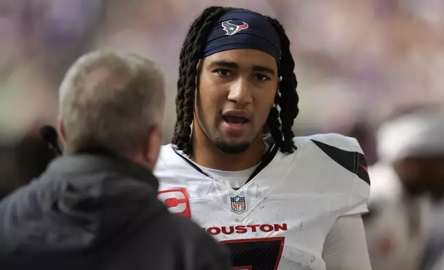 Houston Texans quarterback C.J. Stroud talks with a coach on the sideline during the second half of an NFL football game against the Minnesota Vikings, Sunday, Sept. 22, 2024, in Minneapolis. (AP Photo/Abbie Parr)