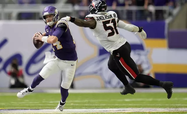 Minnesota Vikings quarterback Sam Darnold (14) runs from Houston Texans defensive end Will Anderson Jr. (51) during the second half of an NFL football game, Sunday, Sept. 22, 2024, in Minneapolis. (AP Photo/Abbie Parr)