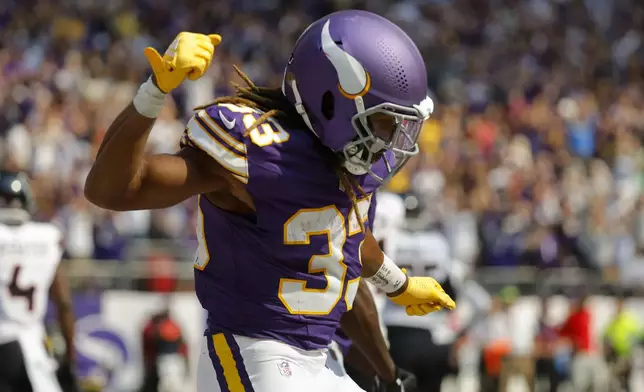 Minnesota Vikings running back Aaron Jones celebrates after catching an 8-yard touchdown pass during the first half of an NFL football game against the Houston Texans, Sunday, Sept. 22, 2024, in Minneapolis. (AP Photo/Bruce Kluckhohn)