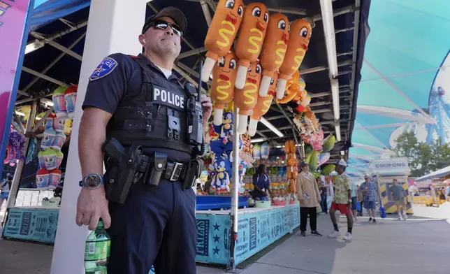 Dallas police officer Luna, stands on watch on the Midway at the State Fair of Texas in Dallas, on Friday, Sept. 27, 2024. (AP Photo/Tony Gutierrez)