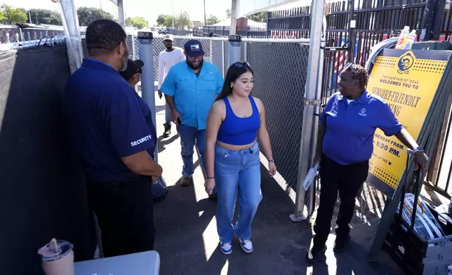 Security personnel watch guests arrive at the State Fair of Texas in Dallas, Friday, Sept. 27, 2024. (AP Photo/Tony Gutierrez)