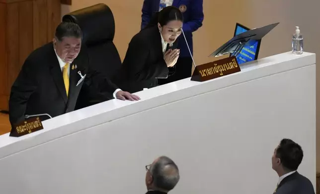 Thailand’s Deputy Prime Minister Phumtham Wechayachai, left, and Prime Minister Paetongtarn Shinawatra greets to lawmaker before making the policy statement at parliament in Bangkok, Thailand, Thursday, Sept. 12, 2024. Paetongtarn appeared Parliament for the first time to lay out how her government envisions to improve the country (AP Photo/Sakchai Lalit)