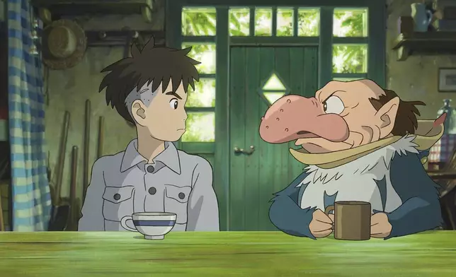 This image released by GKIDS shows Mahito Maki, voiced by Luca Padovan in English and Soma Santoki in Japanese, left, and Grey Heron, voiced by Robert Pattinson in English and Masaki Suda in Japanese, in a scene from Hayao Miyazaki's "The Boy And The Heron." (Studio Ghibli/GKIDS via AP)