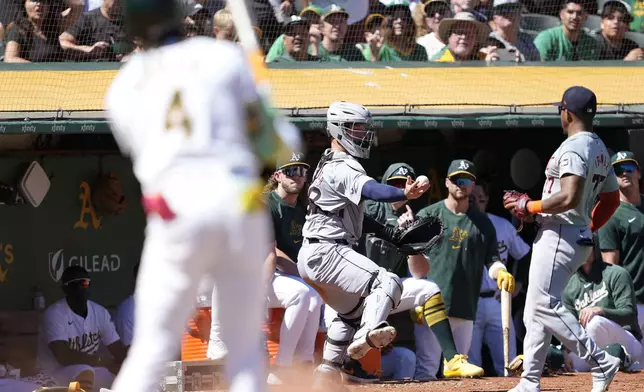 Detroit Tigers catcher Dillon Dingler, center, makes a one-hand catch on a foul ball hit by Oakland Athletics' Lawrence Butler (4) during the fifth inning of a baseball game Saturday, Sept. 7, 2024, in Oakland, Calif. (AP Photo/Tony Avelar)