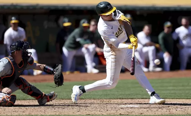 Oakland Athletics' Zack Gelof, right, hits an RBI single in front of Detroit Tigers catcher Jake Rogers, left, during the sixth inning of a baseball game in Oakland, Calif., Sunday, Sept. 8, 2024. (AP Photo/Jed Jacobsohn)