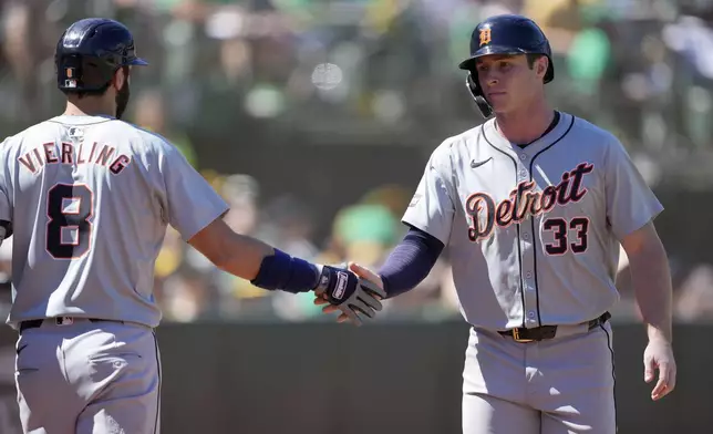 Detroit Tigers' Colt Keith (33) is congratulated by Matt Vierling (8) after scoring a run against the Oakland Athletics during the seventh inning of a baseball game Saturday, Sept. 7, 2024, in Oakland, Calif. (AP Photo/Tony Avelar)