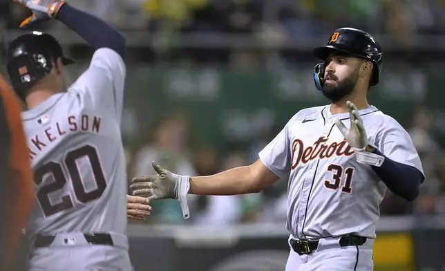 Detroit Tigers' Riley Greene (31) is congratulated by Spencer Torkelson (20) after scoring on an Oakland Athletics wild pitch during the seventh inning of a baseball game Friday, Sept. 6, 2024, in Oakland, Calif. (AP Photo/Tony Avelar)