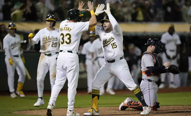 Oakland Athletics' Seth Brown (15) celebrates with JJ Bleday (33) after hitting a 2-run home run against the Detroit Tigers during the 11th inning of a baseball game Friday, Sept. 6, 2024, in Oakland, Calif. (AP Photo/Tony Avelar)