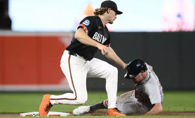 Baltimore Orioles shortstop Gunnar Henderson, left, tags out Detroit Tigers' Kerry Carpenter, right, as he tried to steal second base during the first inning of a baseball game, Friday, Sept. 20, 2024, in Baltimore. (AP Photo/Nick Wass)